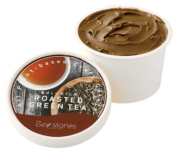 白い紙のカップに茶色のアイスクリームが入っている。その横には、ほうじ茶とその茶葉の写真と商品名が印刷されたカップアイスの蓋が置かれている。