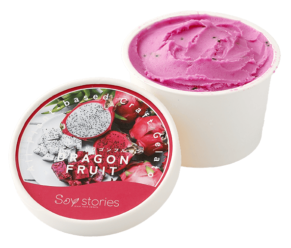 白い紙のカップに濃いピンク色のアイスクリームが入っている。その横には、ドラゴンフルーツの写真と商品名が印刷されたカップアイスの蓋が置かれている。